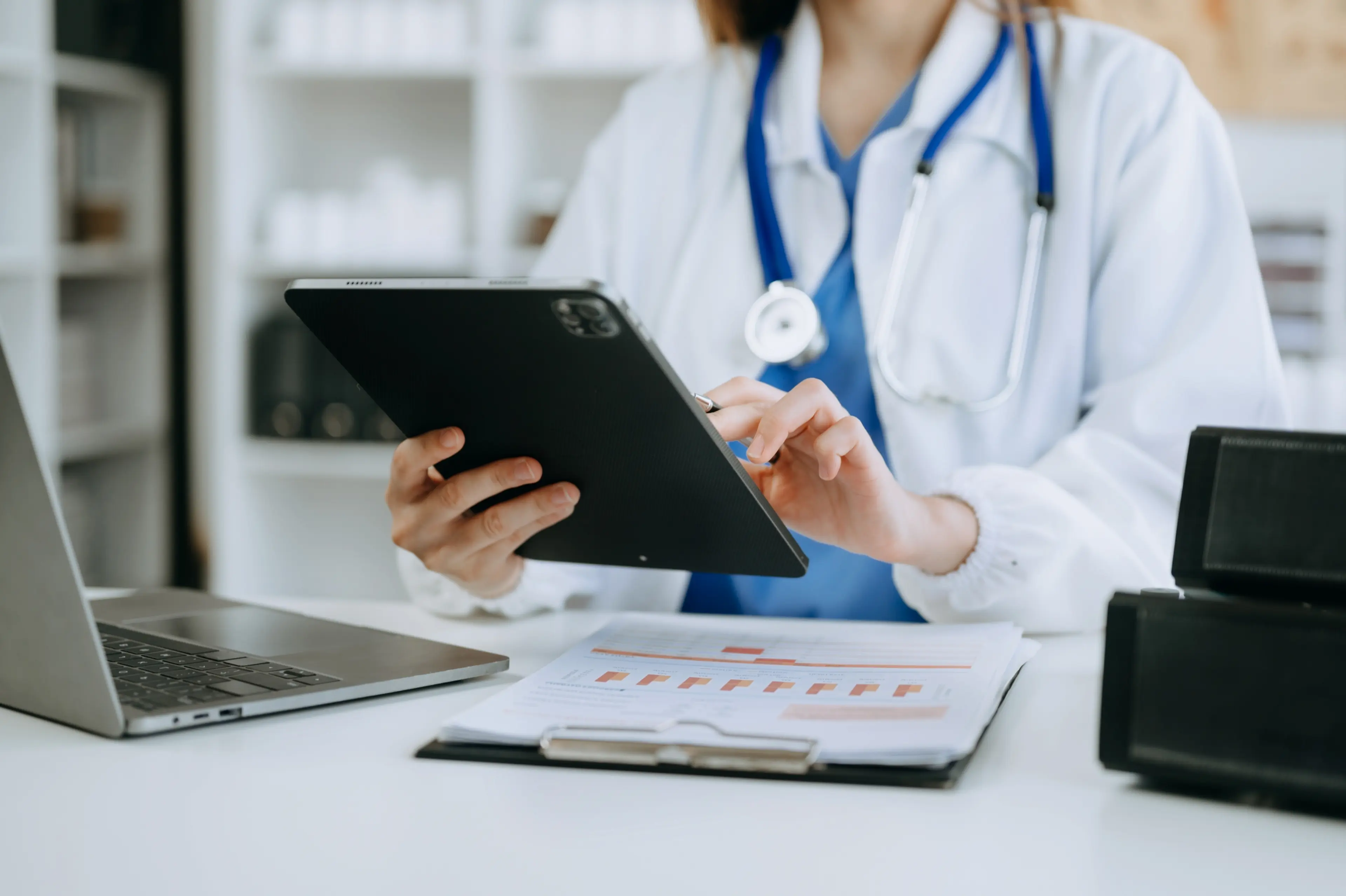 Doctor using a tablet to manage patient data with EHR software developed by ObjectStyle