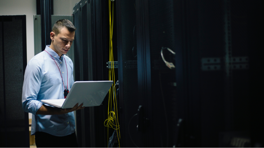 Image of a person working on a laptop, representing datacenter migration and compliance processes.