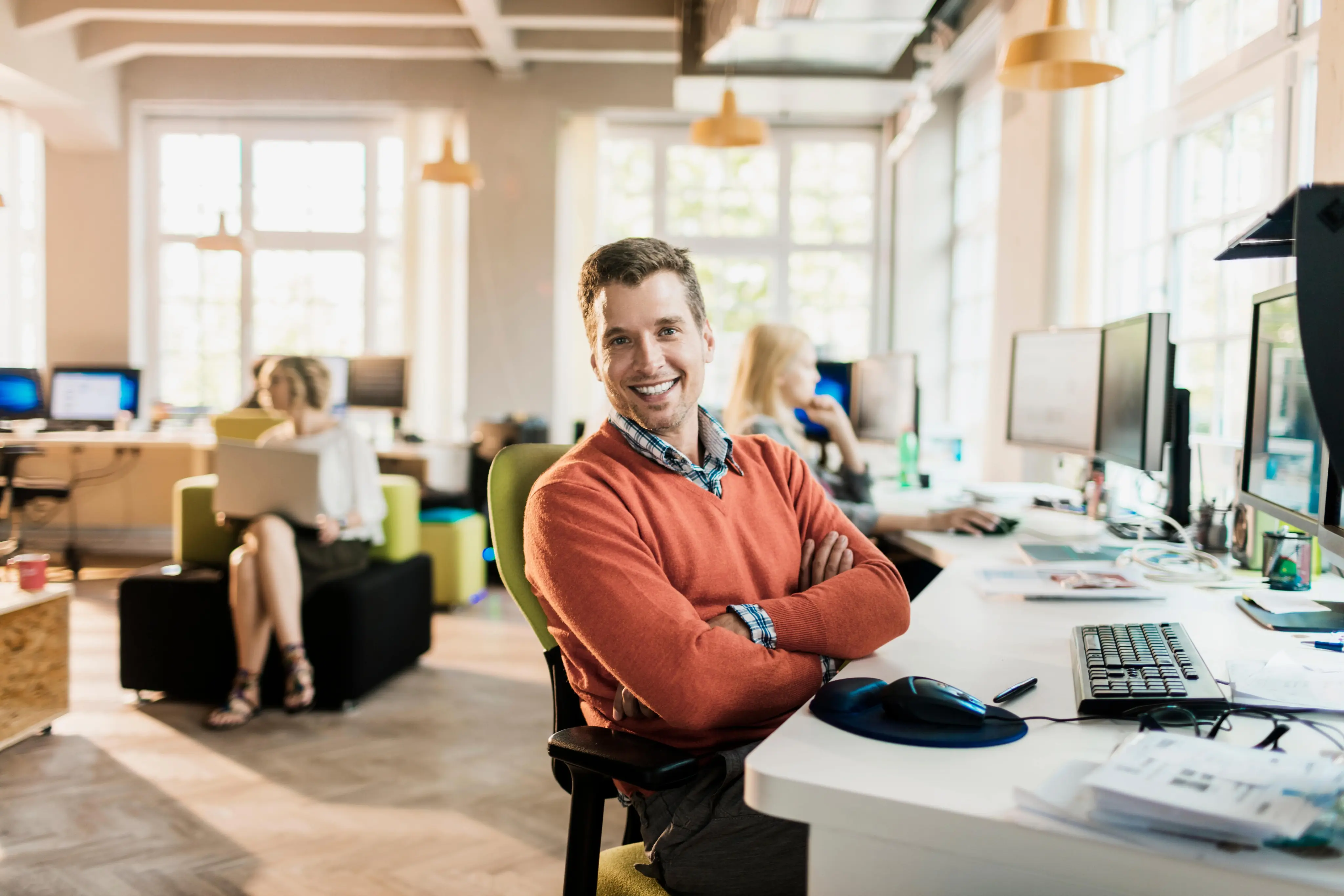 Software development expert at ObjectStyle smiling in a modern office, offering software solutions for startup founders